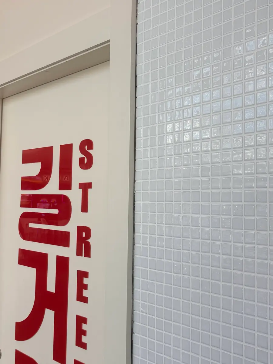Foto del vinilo 길거리 맛 street taste en la puerta del local